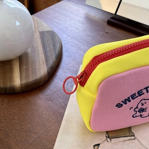 Close-up of yellow and pink cosmetic bag with sweet bear print and red zipper ring