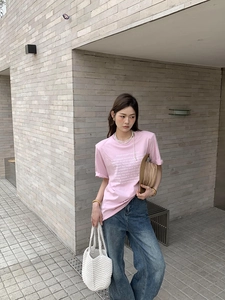 Detail of pink cotton t-shirt with white quote print, round neck, and casual loose fit