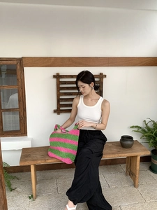 Close-up of handmade striped knit beach tote bag in vibrant green and rose red stripes