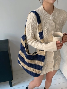 Detail of hand-crocheted stripes and texture on this blue and beige woven tote bag