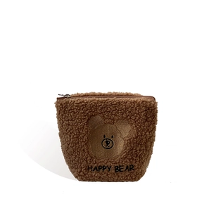Brown fuzzy plush bear makeup bag with Happy Bear embroidery on a white background