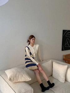 Detail of blue and beige striped straw tote bag paired with a white cable knit dress