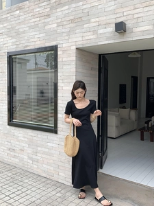 Close-up of a minimalist black short-sleeve slim fit maxi dress with high elasticity