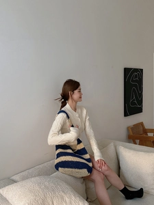 Detail of blue striped woven shoulder bag with thick knit texture on a lifestyle model