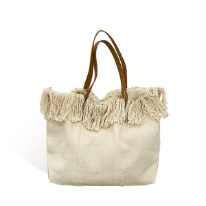 Minimalist off-white woven tote bag with fringe details and long brown leather handles