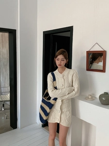 Detail shot of the blue and beige striped woven tote bag paired with a knit cardigan