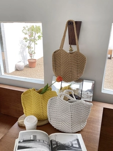Close-up of handmade crochet tote bags in khaki, yellow, and beige with thick cotton texture