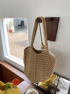 Close-up of khaki hand-woven crochet tote bag showing dense wavy pattern and strap detail