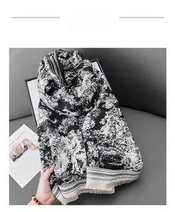 Détail d'une écharpe à imprimé tigre abstrait noir et blanc avec glands décoratifs