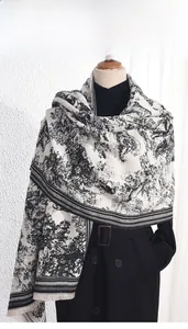 Détail d'un châle imprimé tigre noir et blanc avec franges sur un mannequin de bois