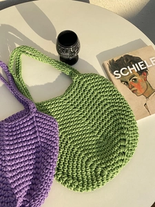 Close-up of handmade crochet texture on oversized purple and green woven cotton beach bags