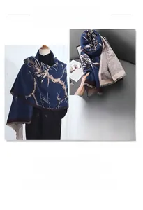 Detail of navy and grey scarf featuring gold branch prints and soft tassel edges