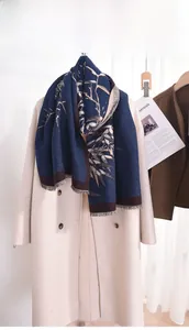 Detail view of navy blue vintage scarf with golden bamboo branch print and soft tassels