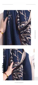 Detail of soft dark blue imitation cashmere scarf with elegant beige tree branch patterns