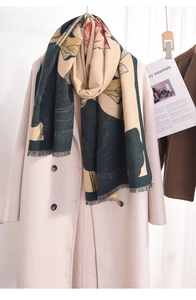 Detail view of lotus print cashmere scarf with fringe on a beige wool coat