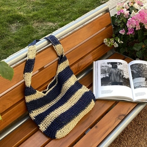 Handmade woven straw tote bag with navy blue and beige stripes for beach travel