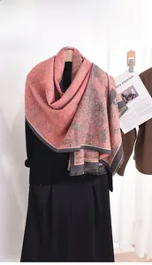 Détail d'une écharpe en jacquard rose et gris avec franges fines et beau drapé