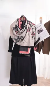 Detail of artistic plum blossom print and fringe tassels on a soft cashmere-feel shawl