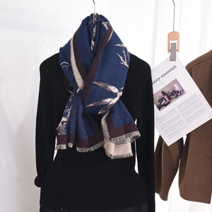 Elegant navy blue scarf with retro branch print and fringe on a black knit top