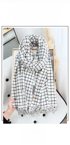 Detailed view of black and white checkered faux cashmere scarf with soft tassel edges