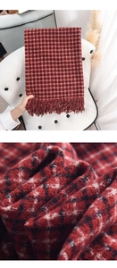 Close-up of soft cashmere-like red and black checkered scarf with tassel detail
