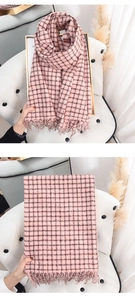 Detail of pink and black plaid cashmere-like scarf showing texture and long fringe edges