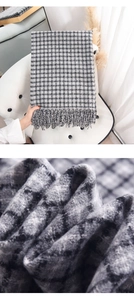 Macro detail of soft cashmere-like grey plaid scarf texture and fringe tassels