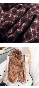Macro shot of thick cashmere-like plaid scarf texture and fringe detail on a white chair