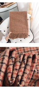 Detail showing the thick soft cashmere-like plaid fabric and long fringes of the scarf