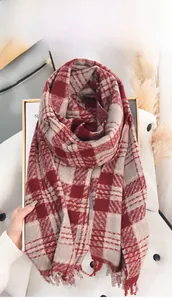 Detailed close-up of red and beige checkered scarf with soft tassel fringe edge details