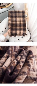 Macro detail of soft cashmere-like plaid scarf featuring thick knit and fringe tassels