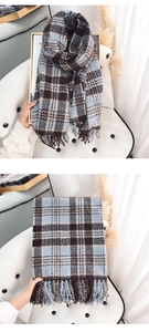 Detailed view of soft plaid cashmere-like scarf with blue and brown fringe tassels