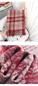 Close-up of red and grey plaid scarf featuring soft cashmere texture and fringe tassels
