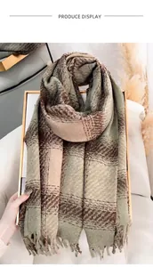 Détail d'une écharpe en maille à carreaux vert sauge et beige avec franges sur support doré