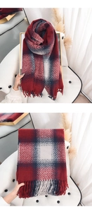 Détail macro d'une écharpe à carreaux rouge avec franges et texture épaisse cachemire
