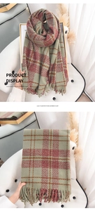 Detail display of green plaid imitation cashmere scarf with fringes on a quilted background