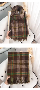 Detail of soft plaid scarf with tassels in brown and green, thick knit winter texture