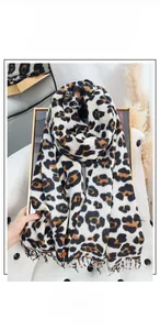 Detail of soft leopard print scarf with fringe edges on a luxury leather seat
