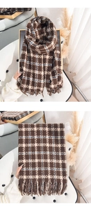 Detailed view of the soft plaid scarf texture and delicate fringe trim in brown