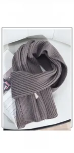 Detail eines dunkelbraunen grob gestrickten Winterschals mit weicher Textur und Webart
