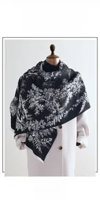 Detail of cashmere-like scarf featuring black and white jungle toile de jouy jacquard pattern