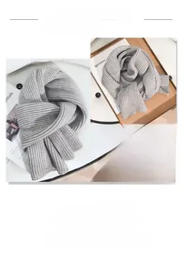 Detail eines grauen Strickschals mit dicker Rippenstruktur und weichem Wintergewebe