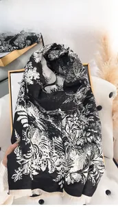 Detailed view of autumn winter thick scarf featuring white floral patterns and soft fringes