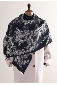 Detail of black and white floral cashmere scarf with vintage botanical prints and fringe