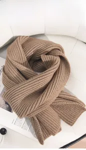 Detailansicht der vertikal gerippten Strickstruktur eines dicken kamelfarbenen Schals