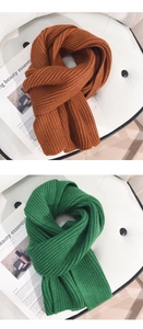 Detaillierte Nahaufnahme von gerippten Strickschals in Karamelorange und Smaragdgrün-Textur