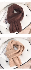 Detail von gerippten Winterstrickschals in Dunkelbraun und Beige auf einem Sessel