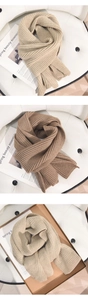 Nahaufnahme der dicken Rippstrick-Textur von einfarbigen Winter-Strickschals in Beige und Braun