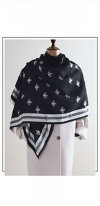 Détail d'une écharpe en cachemire synthétique noir avec motif abeille jacquard et franges