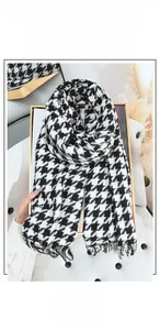Detail of classic black and white houndstooth scarf with elegant tassel fringe